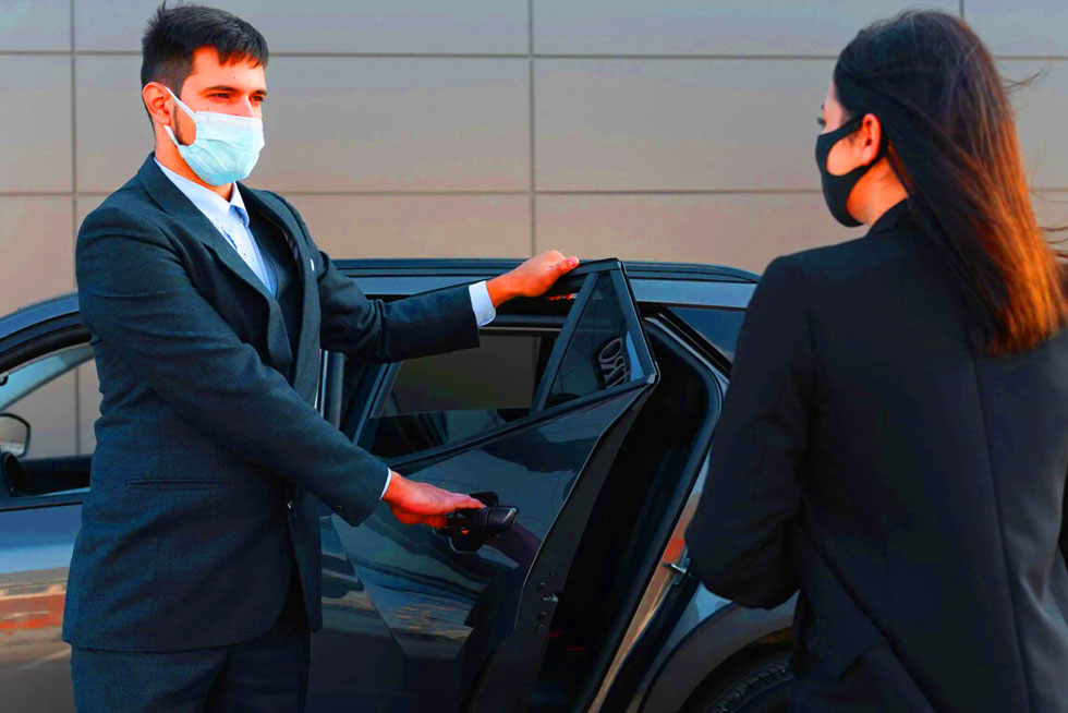 Airport transfers NYC showing yellow taxi and shuttle bus at JFK terminal with travelers and luggage