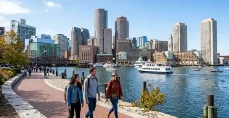 Passeio Boston pela orla com turistas caminhando diante do skyline e do porto de Boston
